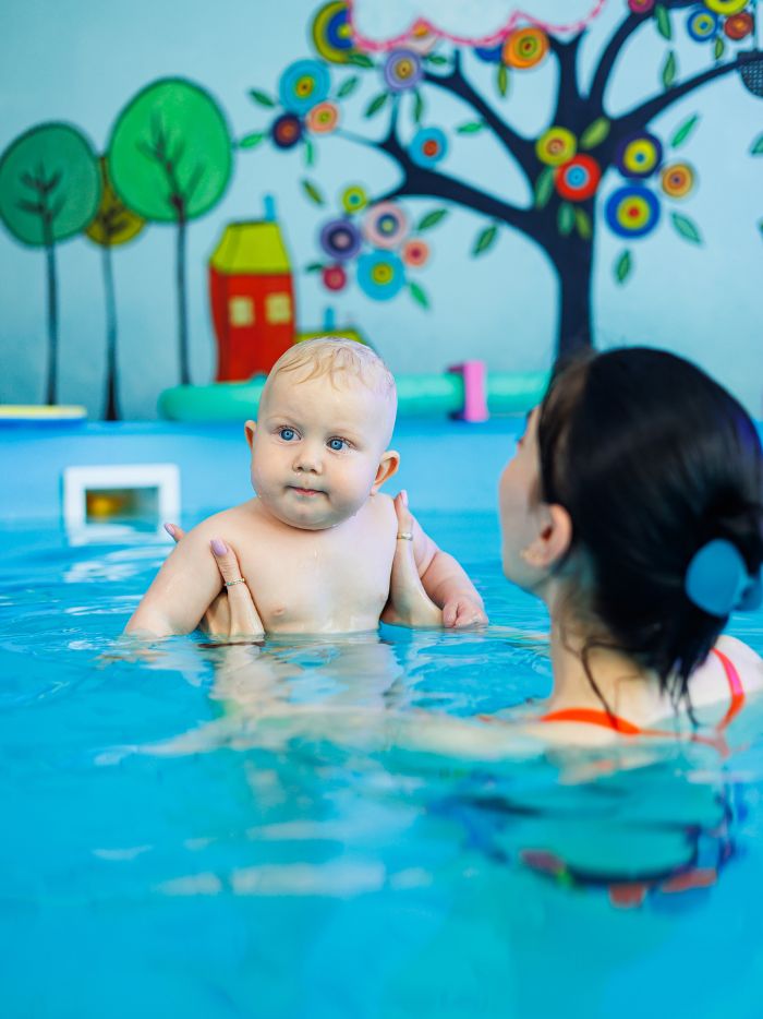 Moment de confiance dans l'eau entre parent et bébé
